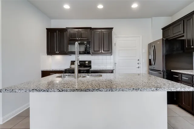 a kitchen with stainless steel appliances a sink a stove a microwave and cabinets