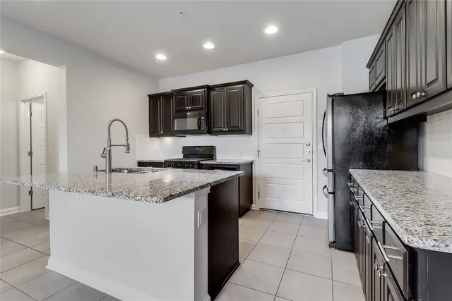 a kitchen with stainless steel appliances granite countertop a sink a stove and microwave
