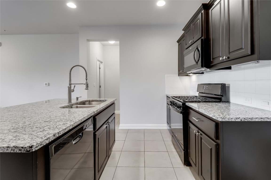 6814 East Riverside Drive, Unit 32 Austin, TX 78741 - Photo 25 of 27 a kitchen with stainless steel appliances granite countertop a sink stove and cabinets