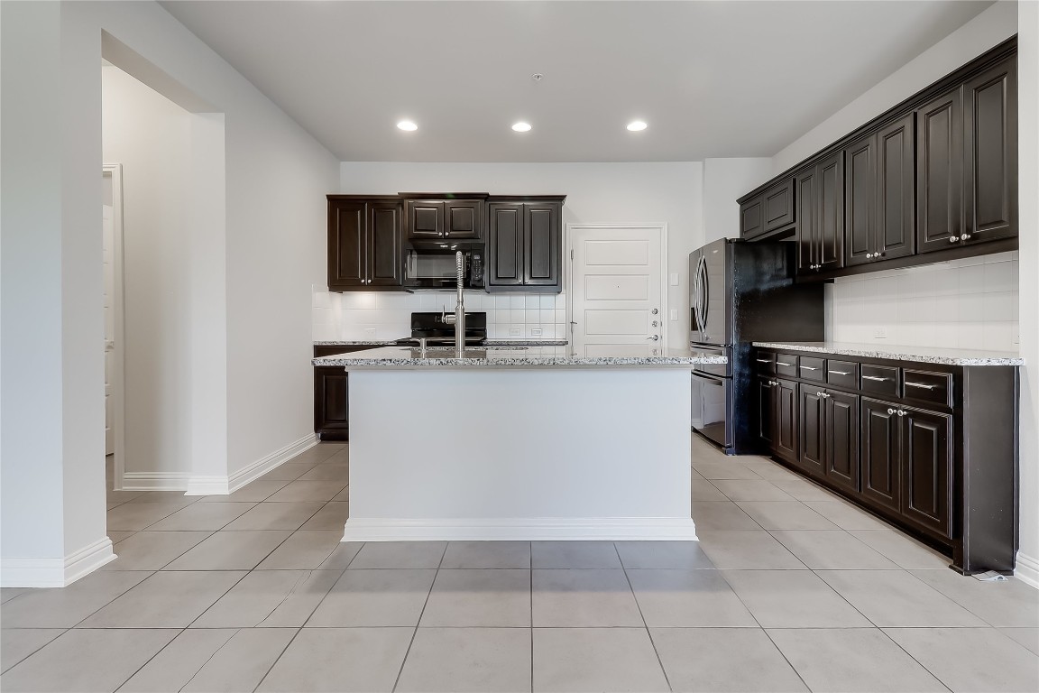 6814 East Riverside Drive, Unit 32 Austin, TX 78741 - Photo 9 of 27 a kitchen with stainless steel appliances a sink a stove a microwave and cabinets