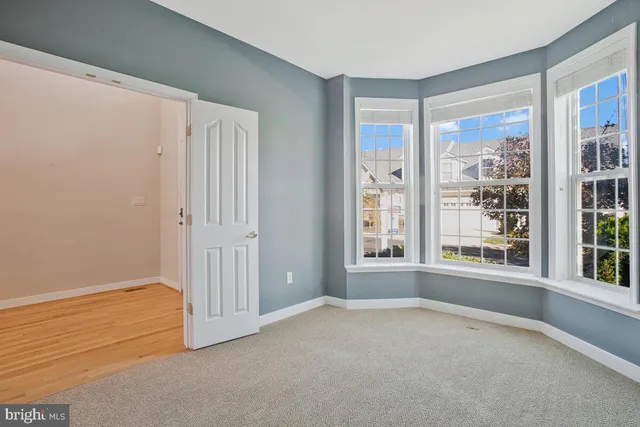 a view of a livingroom with wooden floor a fireplace and windows
