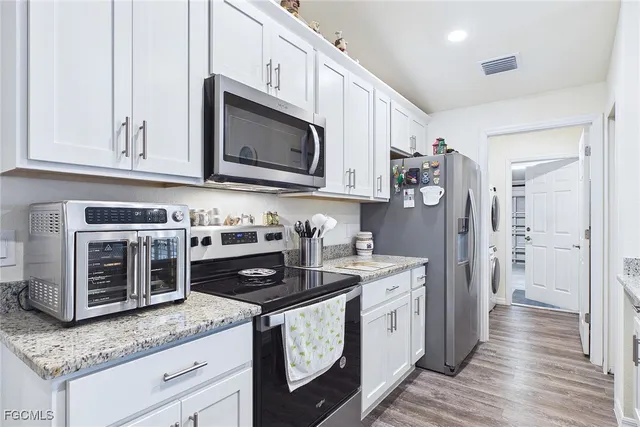 a kitchen with stainless steel appliances granite countertop a stove a sink and a microwave