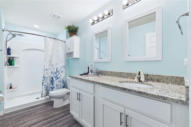 a bathroom with a granite countertop sink toilet and shower