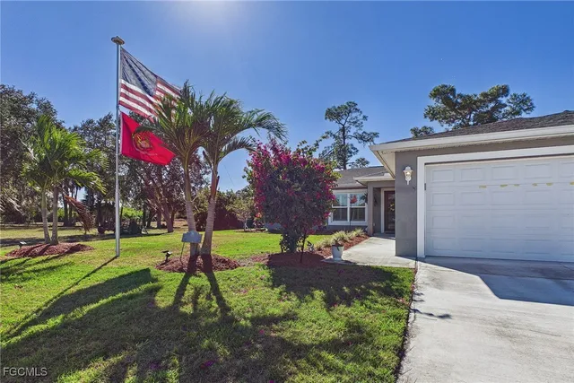 a view of a house with a yard and potted plants