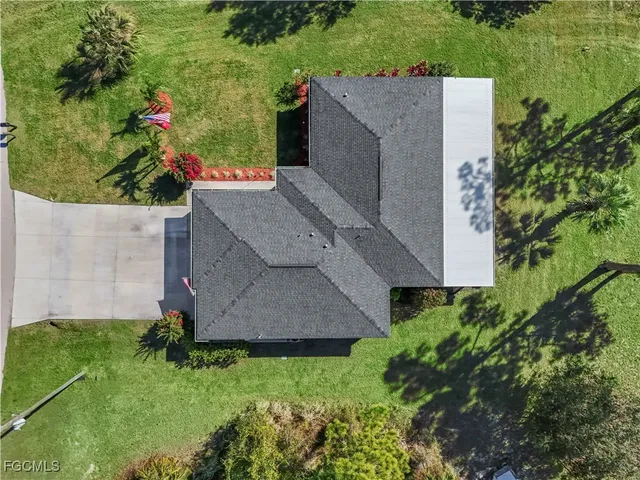an aerial view of a house with swimming pool garden and mountain view in back