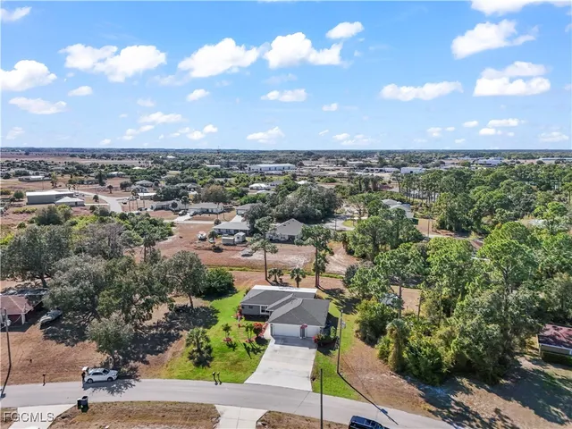 an aerial view of residential houses with outdoor space and trees