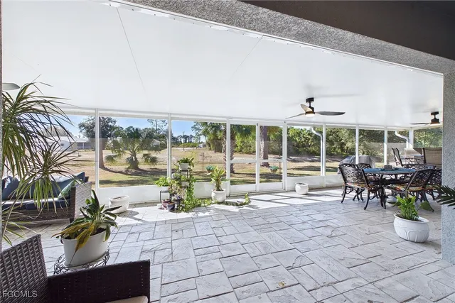 a view of a patio with a dining table and chairs with wooden floor