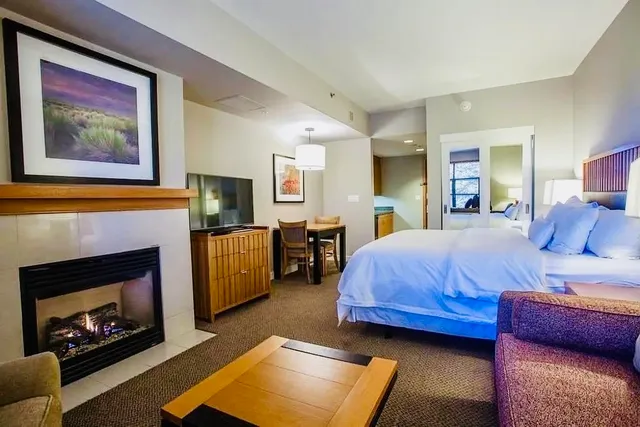 a spacious bedroom with a bed a couch and a fireplace