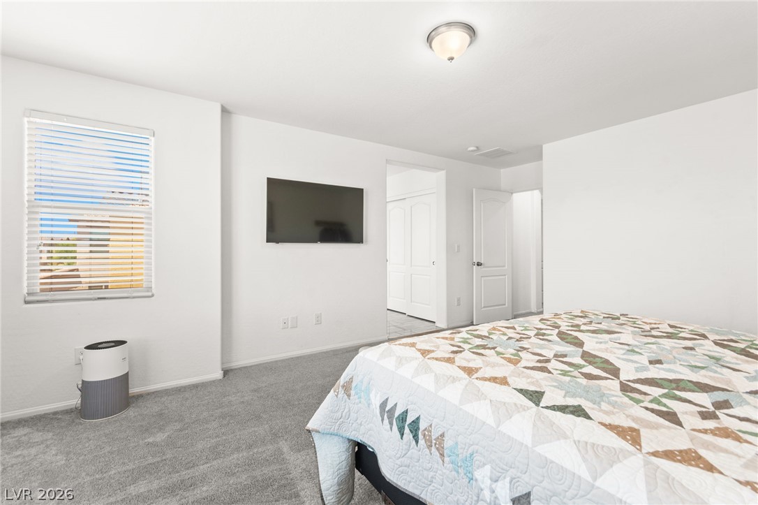 6435 Point Isabel Way Las Vegas, NV 89122 - Photo 26 of 57 Natural light streams into this serene bedroom, highlighting the plush carpet and bright walls.