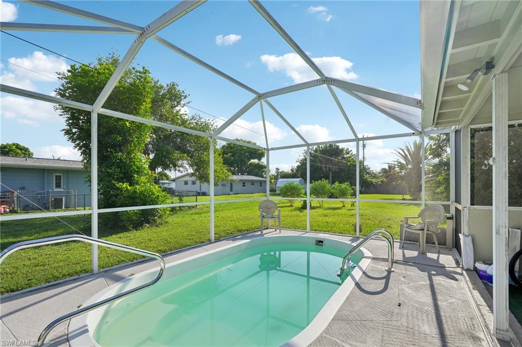501 Penn Road West Lehigh Acres, FL 33936 - Photo 8 of 27 a view of a backyard with swimming pool table and chairs