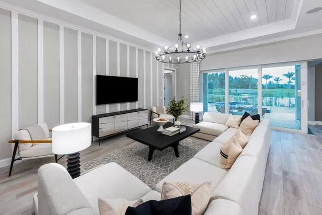 a living room with furniture a chandelier and a flat screen tv