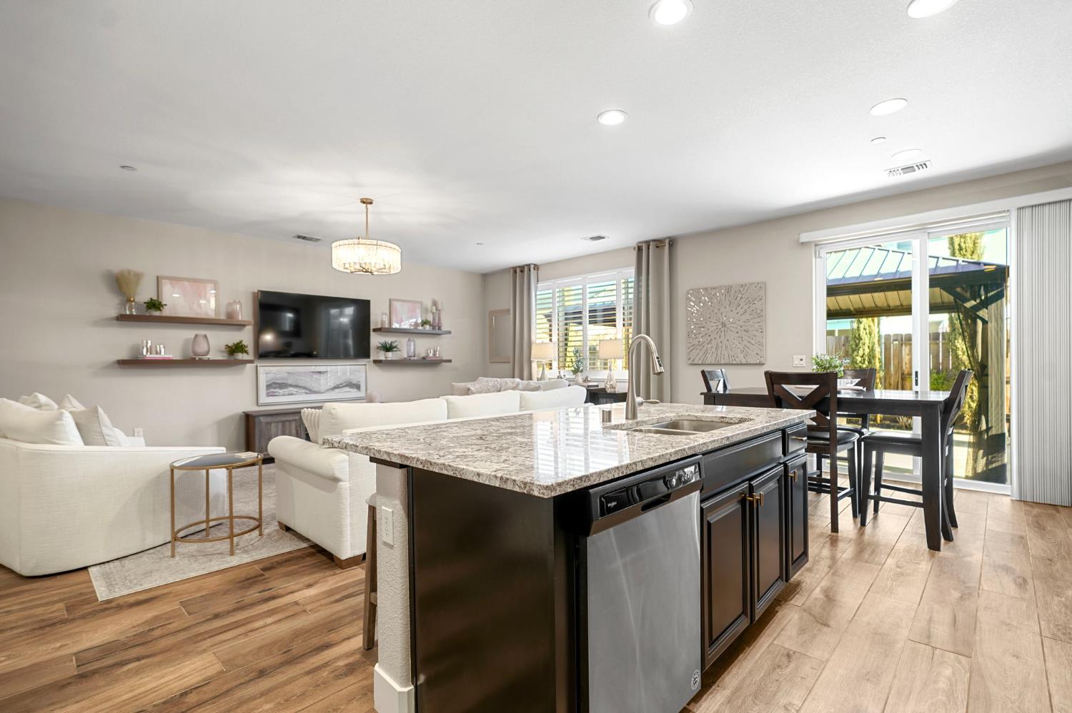 1642 Mcmanis Lane Ripon, CA 95366 - Photo 18 of 44 a open kitchen with white cabinets a sink dishwasher and a stove with wooden floor