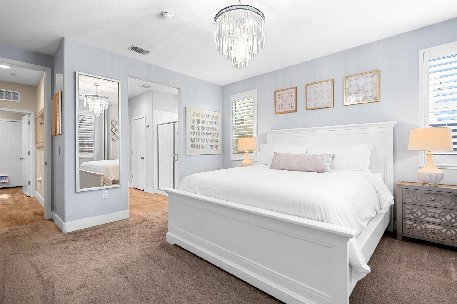 1642 Mcmanis Lane Ripon, CA 95366 - Photo 27 of 44 a bedroom with a bed and a chandelier