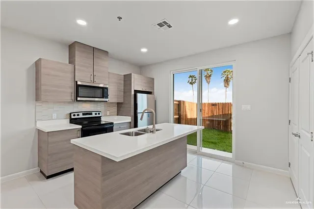 a kitchen with a sink a counter top space appliances and cabinets
