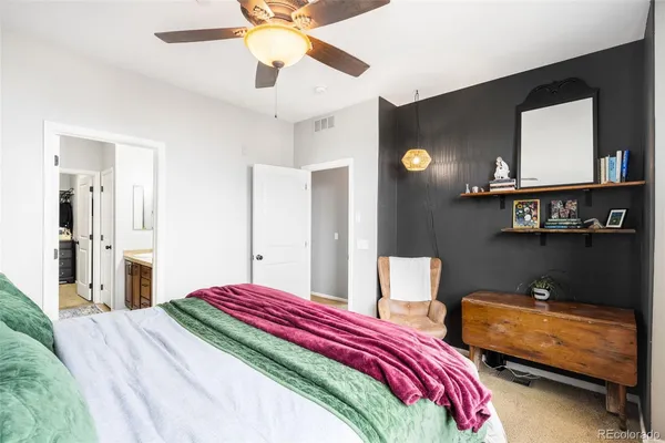 a bedroom with a bed and a mirror on the dresser