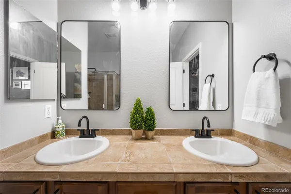 a bathroom with double vanity sinks and two mirror