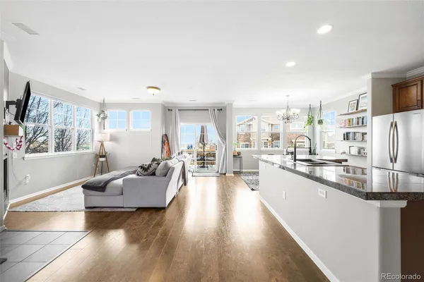 a large living room with stainless steel appliances furniture a rug and a kitchen view