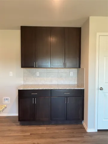 a view of a kitchen with wooden floor and cabinets