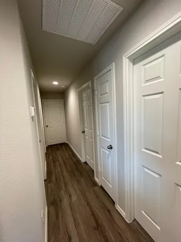a view of a hallway with wooden floor