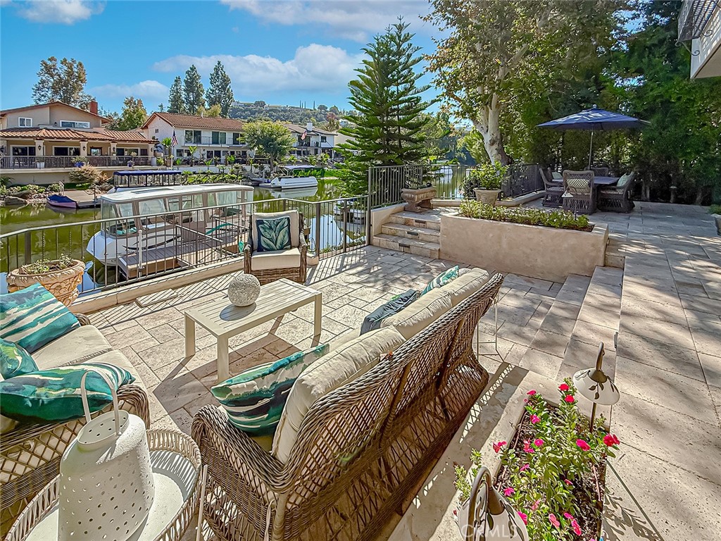 3826 Bowsprit Circle Westlake Village, CA 91361 - Photo 57 of 72 a view of a patio with couches table and chairs under an umbrella with a garden