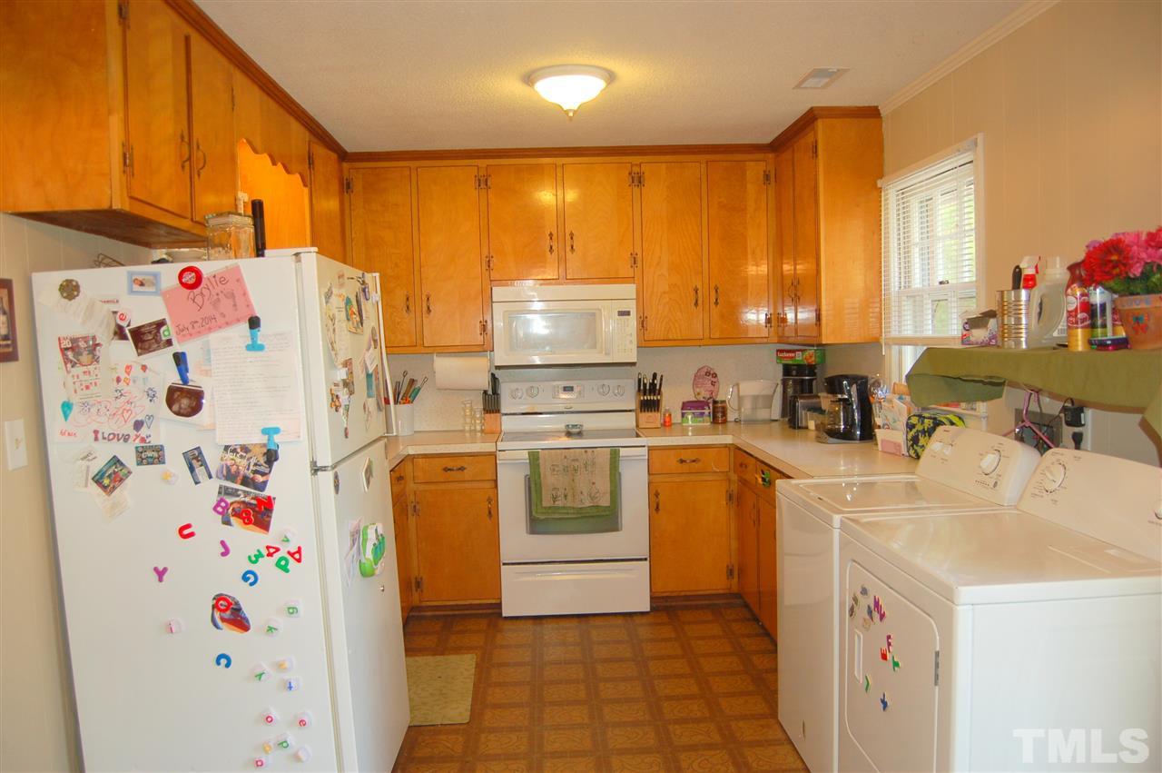 1013 Variform Road Durham, NC 27712 - Photo 22 of 25 a kitchen with a refrigerator a stove a washer dryer and a dining table