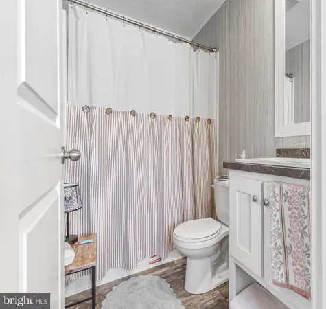 a bathroom with a toilet and a shower curtain