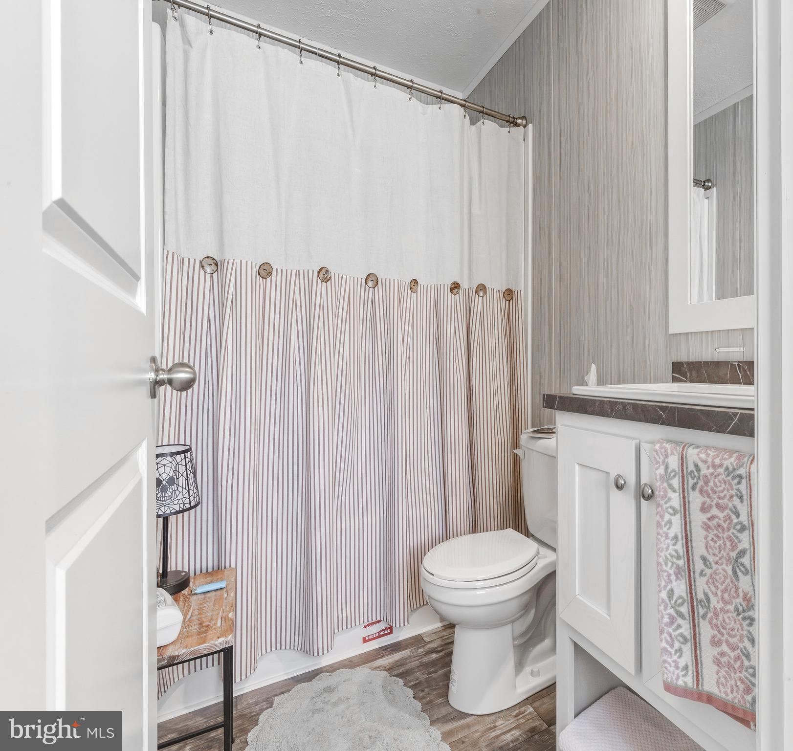 260 Marshall Mill Road, Unit 132 Malaga, NJ 08328 - Photo 2 of 11 a bathroom with a toilet and a shower curtain