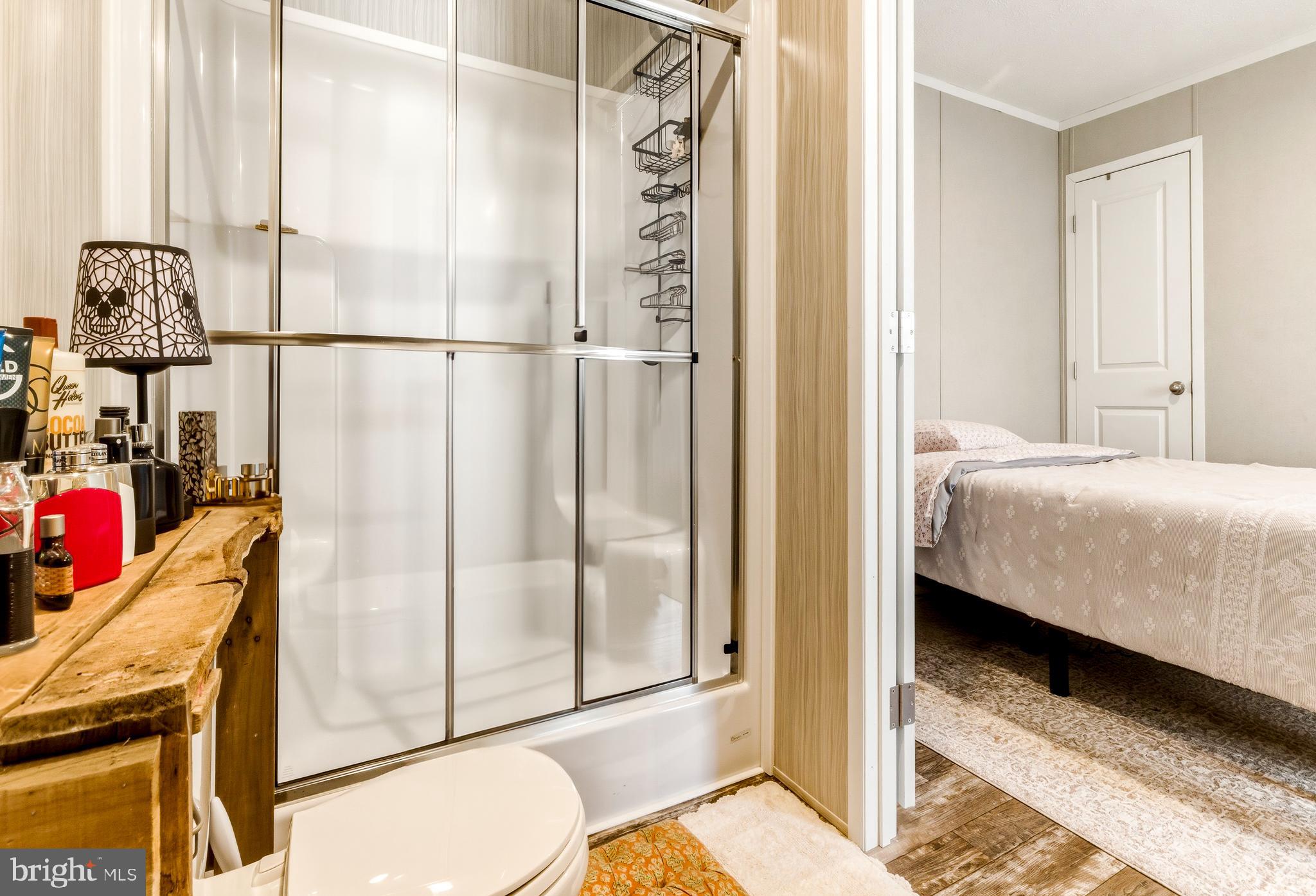 260 Marshall Mill Road, Unit 132 Malaga, NJ 08328 - Photo 5 of 11 a bedroom with a bed and glass door