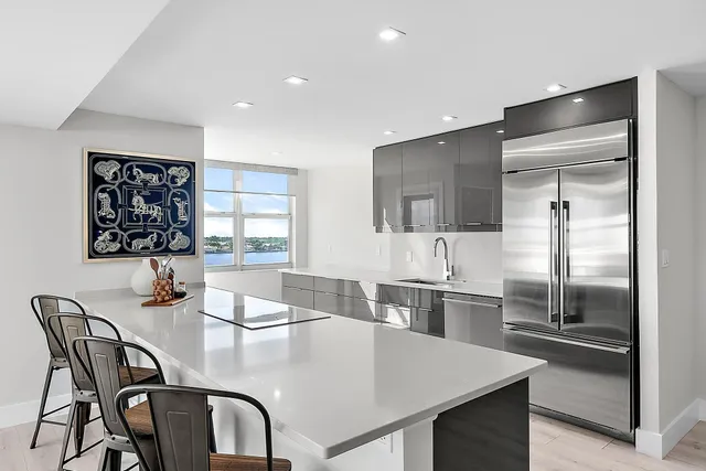 a kitchen with stainless steel appliances granite countertop a kitchen island a stove a table and chairs