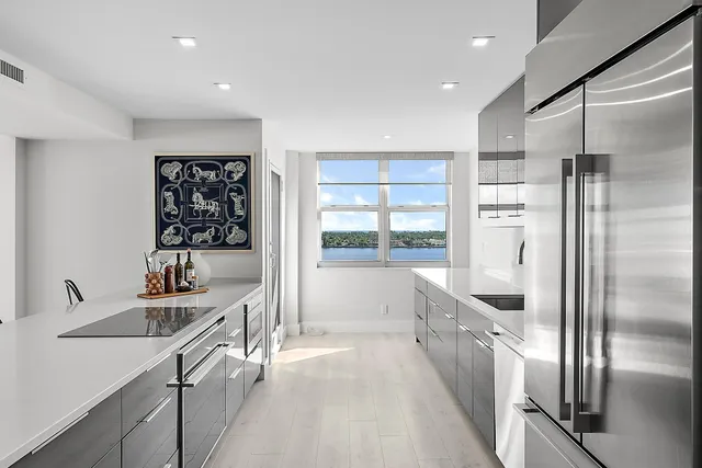 a kitchen with stainless steel appliances granite countertop a refrigerator a sink and a stove