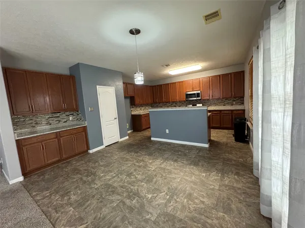 a view of kitchen and refrigerator in kitchen