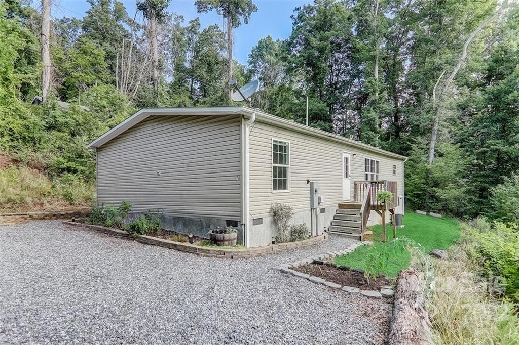 78 Alexander Road Alexander, NC 28701 - Photo 2 of 21 a view of a backyard with plants and large tree