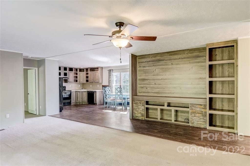78 Alexander Road Alexander, NC 28701 - Photo 9 of 21 a view of a livingroom with a fireplace a chandelier and windows