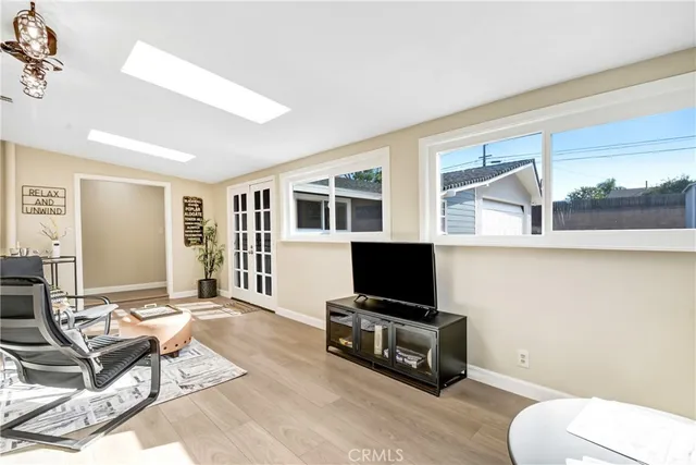 a living room with furniture a flat screen tv and a window