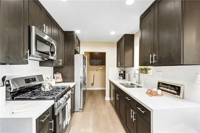 a kitchen with stainless steel appliances a sink stove and refrigerator