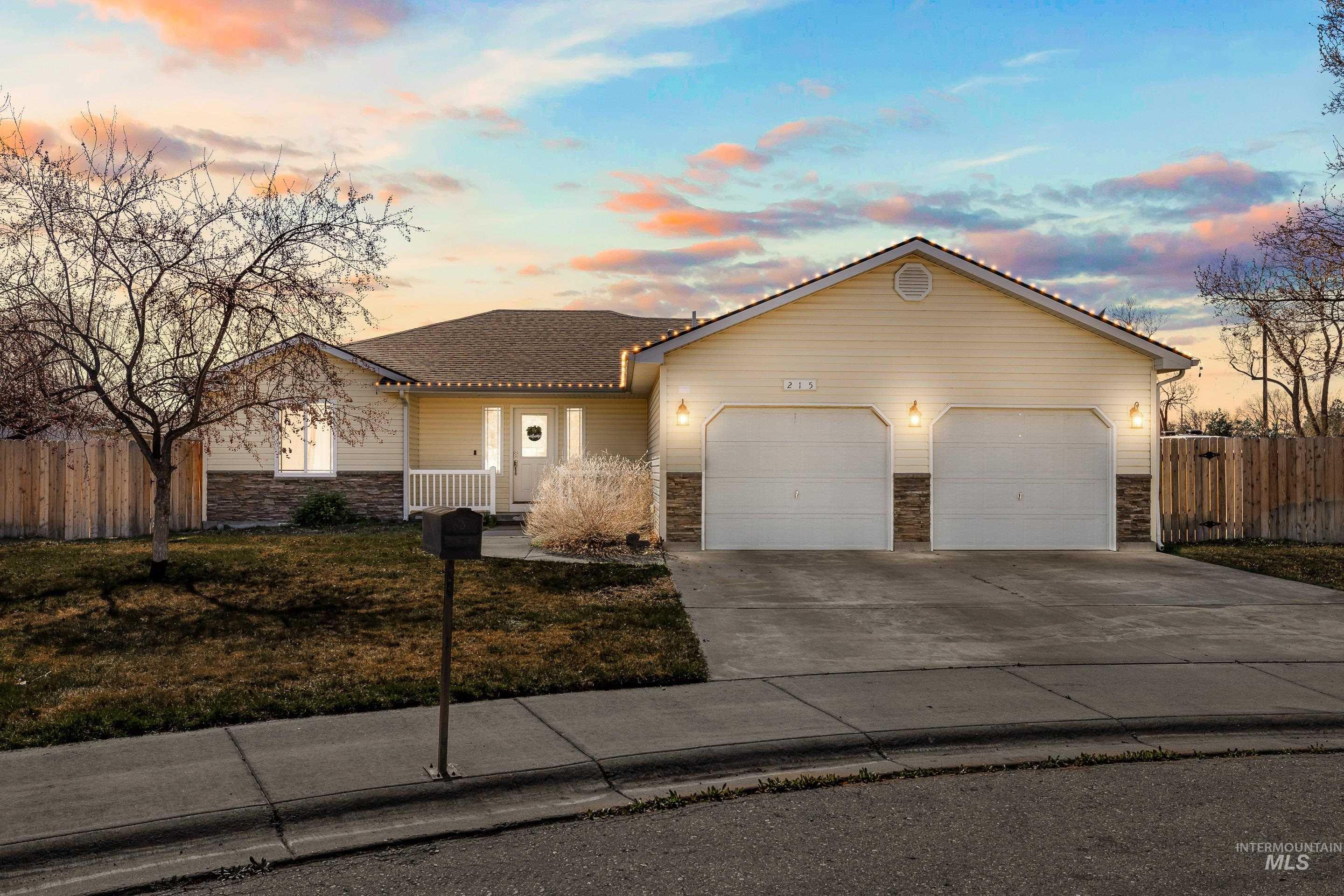 Single story home with stone siding, an attached garage, and concrete driveway