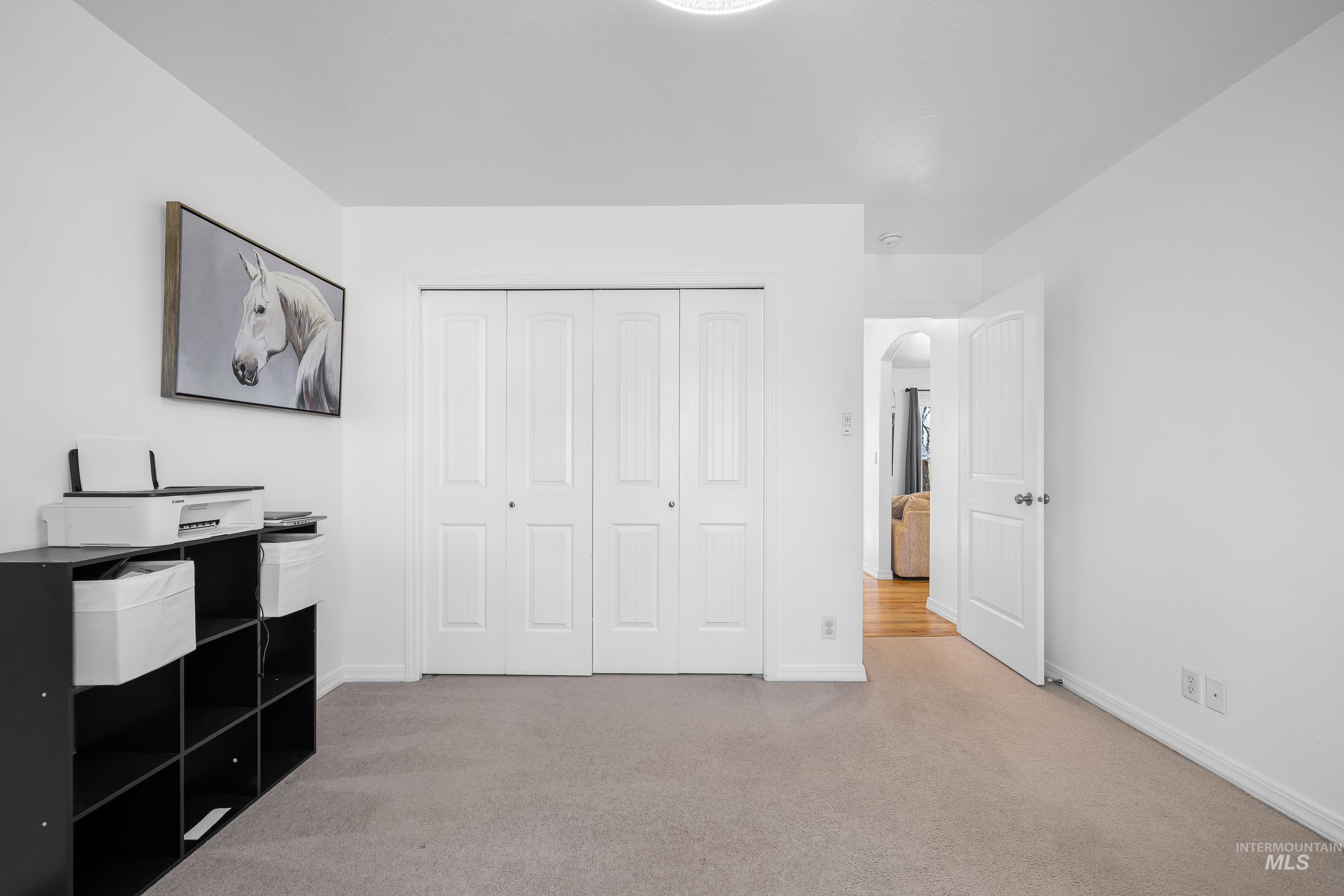 215 Northeast Rosa Court Mountain Home, ID 83647 - Photo 33 of 39 Unfurnished bedroom with light colored carpet, arched walkways, and a closet