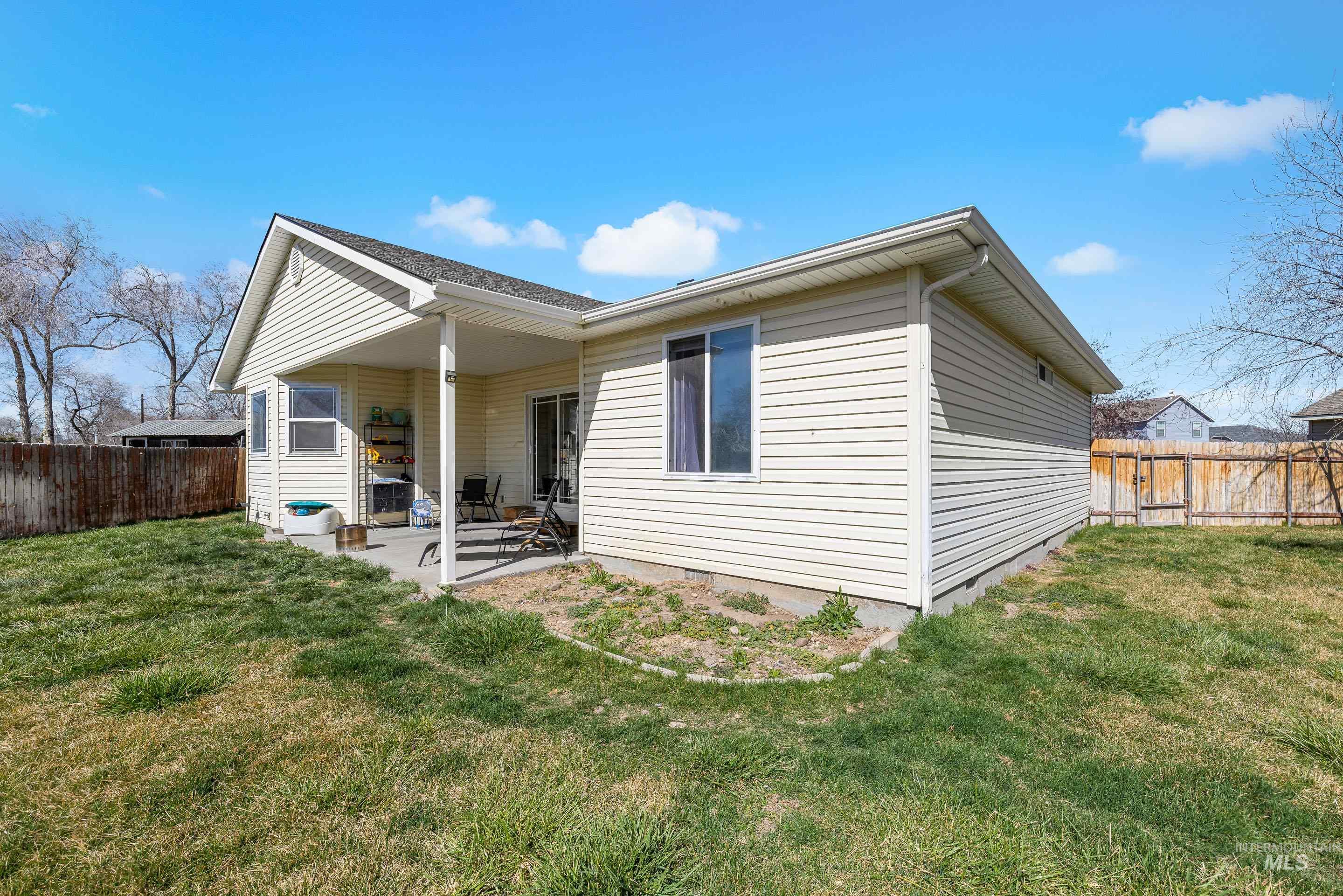 215 Northeast Rosa Court Mountain Home, ID 83647 - Photo 36 of 39 Rear view of house featuring a fenced backyard and a patio area