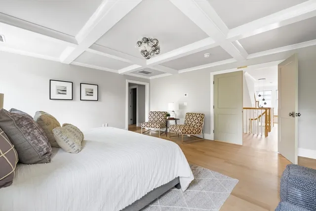 a spacious bedroom with a large bed and a chandelier