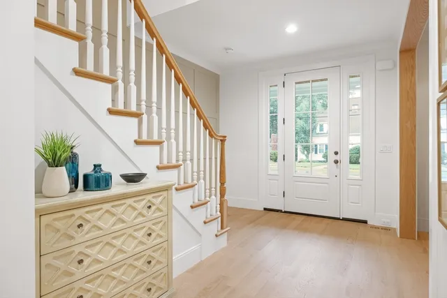a view of front door with wooden floor and stairs