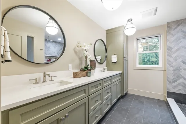 a en suite bathroom with a granite countertop double vanity and a mirror