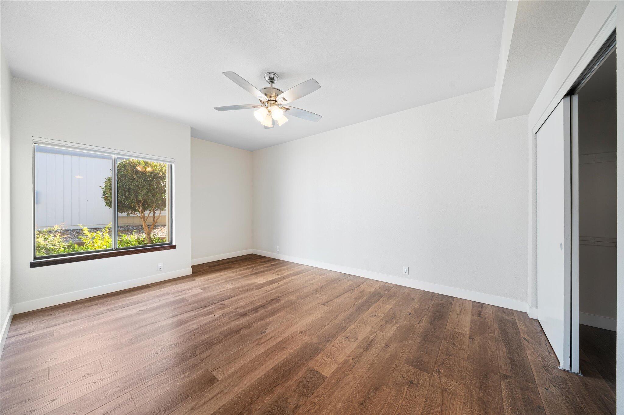 488 Ridgecrest Trail, Unit 132 Redding, CA 96003 - Photo 22 of 51 an empty room with wooden floor chandelier fan and windows