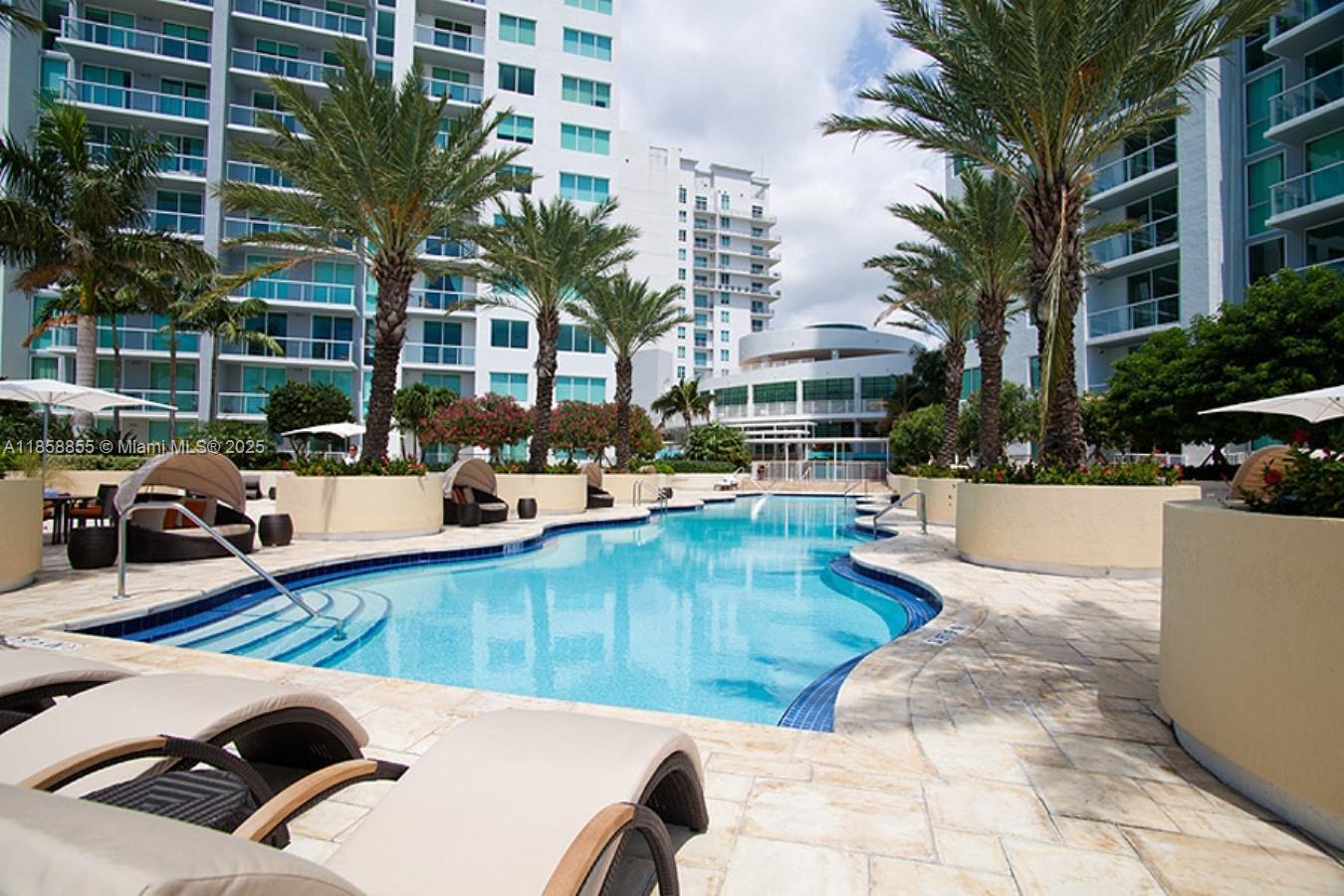 253 Northeast 2nd Street, Unit 3302 Miami, FL 33132 - Photo 20 of 27 a view of a swimming pool with lounge chair and palm trees