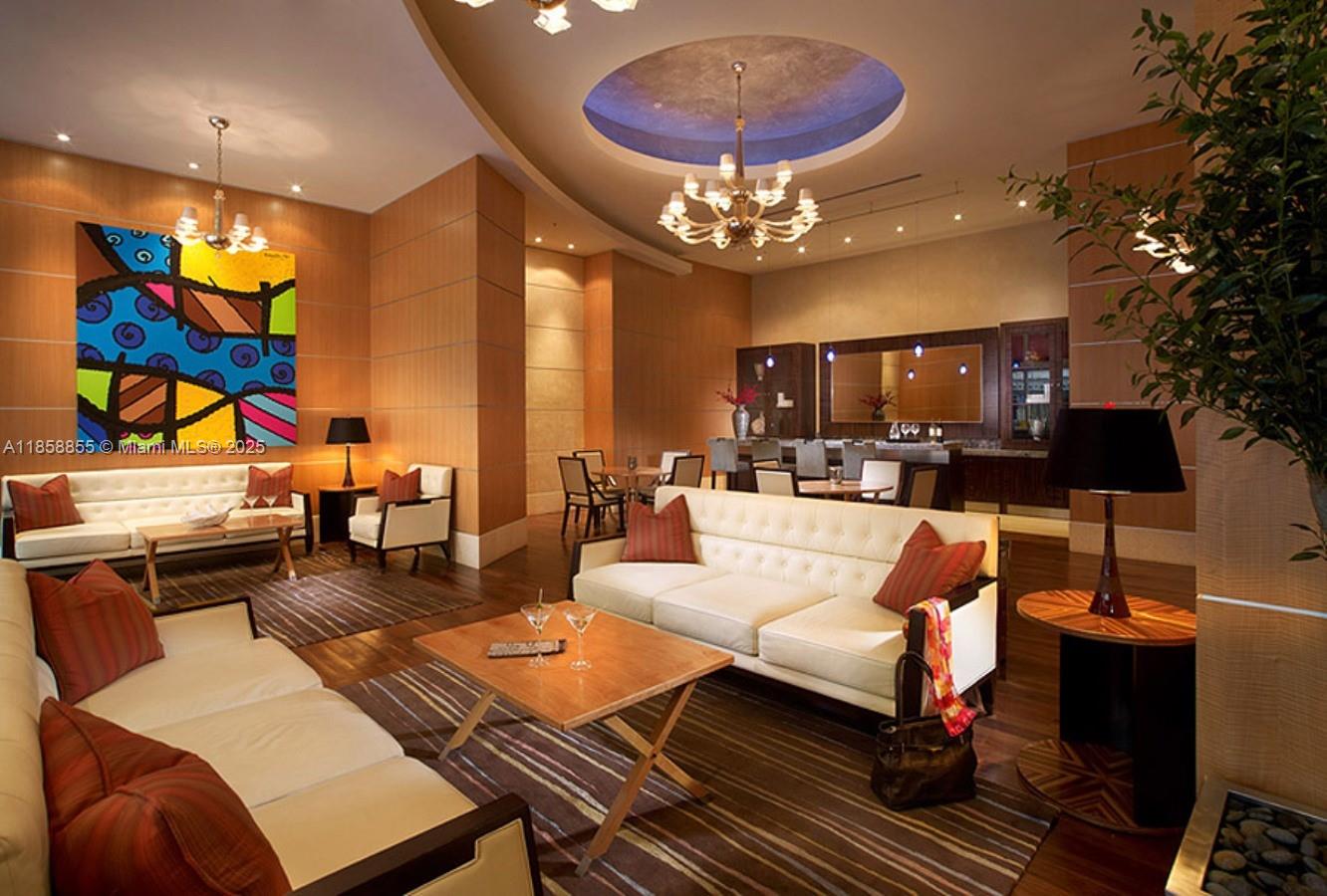 253 Northeast 2nd Street, Unit 3302 Miami, FL 33132 - Photo 22 of 27 a living room with furniture a chandelier and a dining table