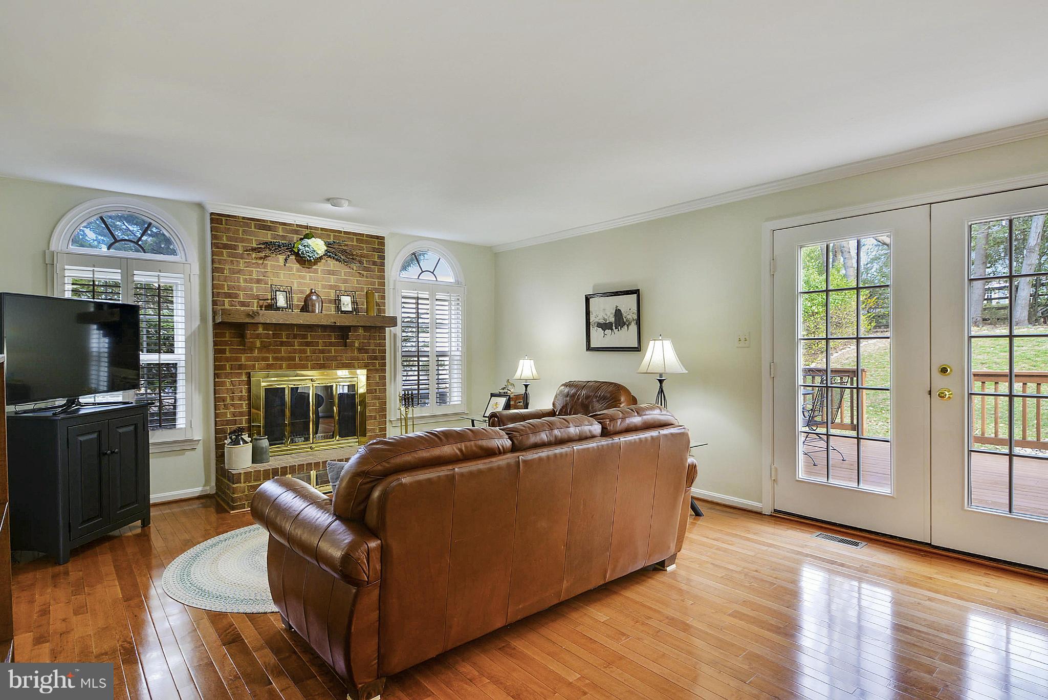 11952 Grey Squirrel Lane Reston, VA 20194 - Photo 8 of 30 a living room with furniture a flat screen tv and a fireplace