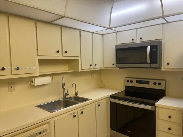 a kitchen with stainless steel appliances granite countertop a sink a stove and a microwave