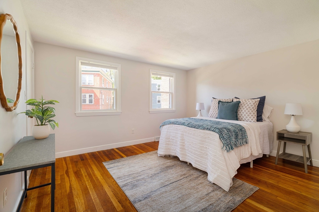 24 Goldsmith Street, Unit 24 Boston, MA 02130 - Photo 11 of 23 a bedroom with a bed lamp and a potted plant