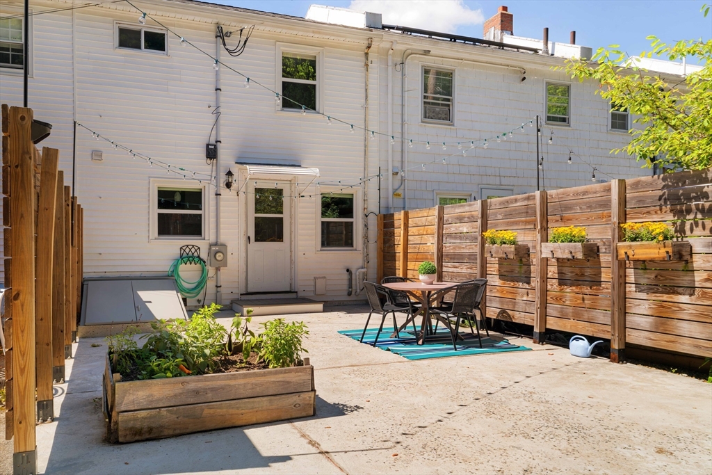 24 Goldsmith Street, Unit 24 Boston, MA 02130 - Photo 21 of 23 a front view of a house with outdoor seating area and barbeque oven