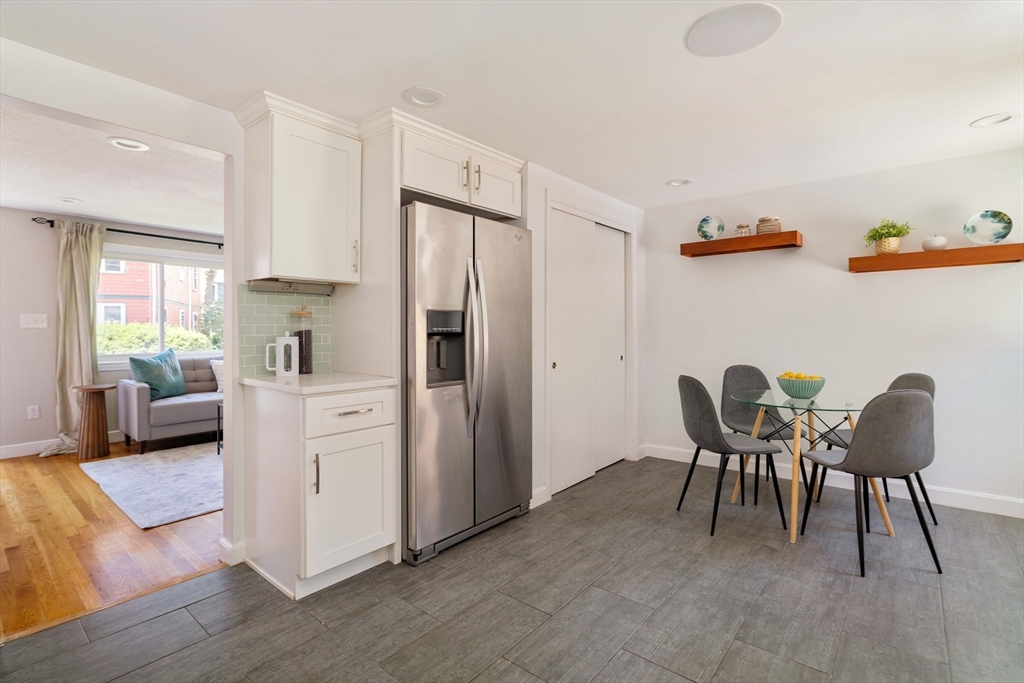 24 Goldsmith Street, Unit 24 Boston, MA 02130 - Photo 10 of 23 a kitchen with stainless steel appliances granite countertop a refrigerator a dining table and chairs