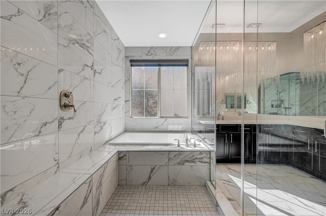 3943 Reyes Avenue Las Vegas, NV 89141 - Photo 37 of 95 Marble tiling and sleek glass enclosure elevate this refined bathroom retreat.